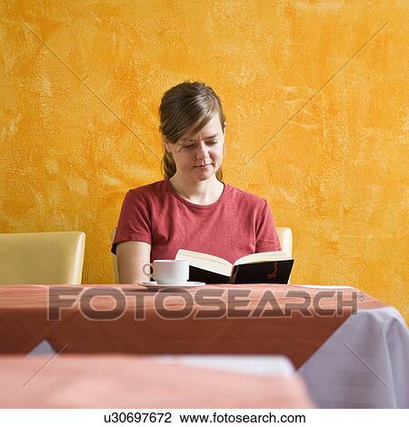 Stock Image - Women with a cup of coffee while reading. Fotosearch