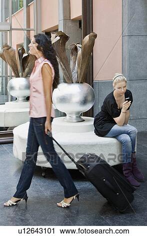 Women with luggage and cellular phone View Large Photo Image Stock Image - Women with luggage and cellular phone. Fotosearch