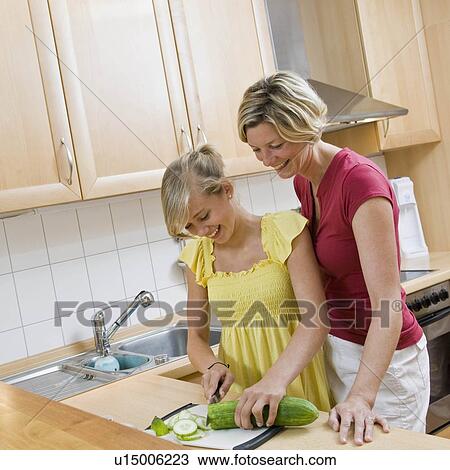 Young girl and woman preparing meal View Large Photo Image Stock Image - Young girl and woman preparing meal. Fotosearch