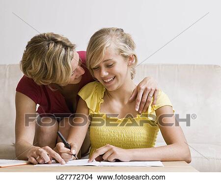 Young girl doing homework with woman View Large Photo Image Picture - Young girl doing homework with woman. Fotosearch