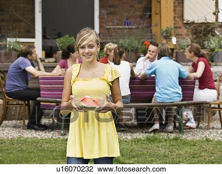 Stock Image - Young girl holding watermelon. Fotosearch