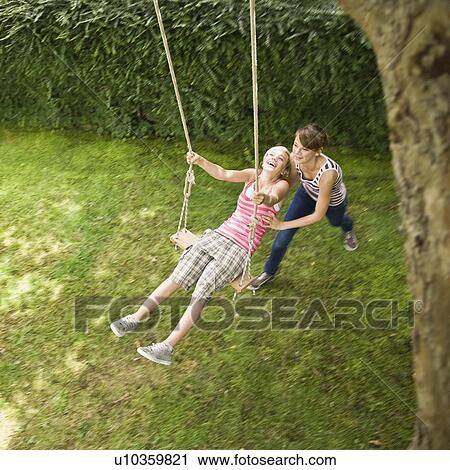 Young girl on a tree swing View Large Photo Image Stock Image - Young girl on a tree swing. Fotosearch