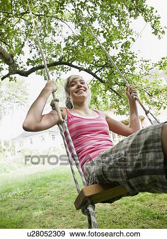 Stock Photo - Young girl on a tree swing. Fotosearch