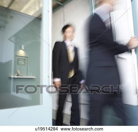 Picture - Businesswoman and Businessman Walking Through Door. Fotosearch