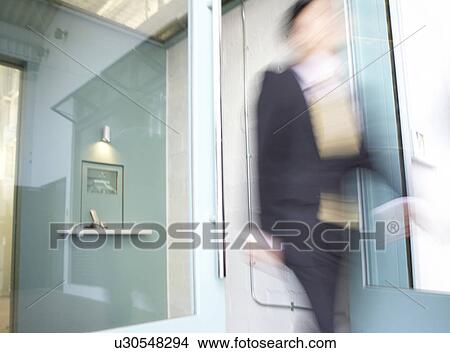 Picture - Businesswoman Walking Through Doors. Fotosearch
