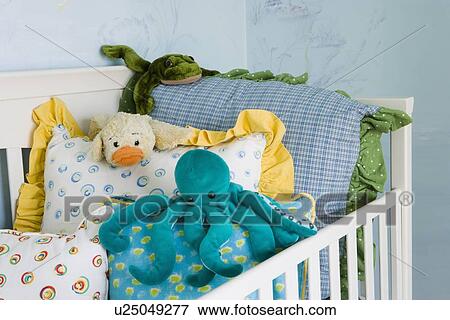Stock Photo - Children's stuffed toys on throw pillows in crib. Fotosearch