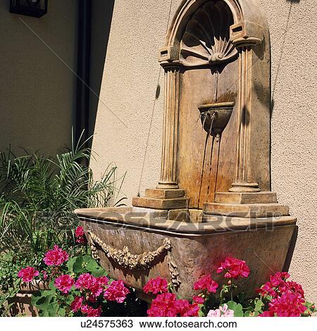 Stock Image - Detail decorative fountain on side of house. Fotosearch