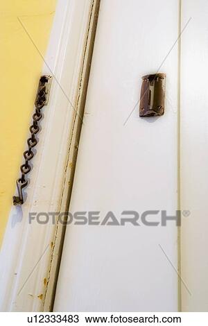 Stock Image - Detail door with safety chain lock. Fotosearch