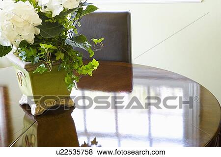 Stock Photo - flower arrangement on center of reflective table. Fotosearch