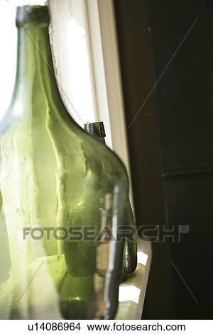 Picture - Glass bottles along window sill. Fotosearch