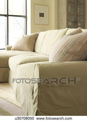 Stock Image - Light colored sofa with striped throw pillow. Fotosearch