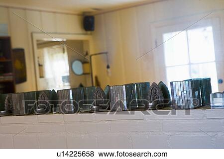 Stock Photo - Row of candle holders on mantle in front of mirror. Fotosearch