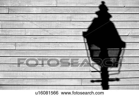 Stock Photograph - Shadow of street lamp on wood siding. Fotosearch