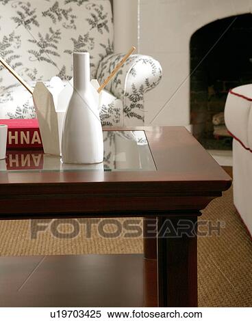 Stock Photography - Take out container and saki on coffee table. Fotosearch