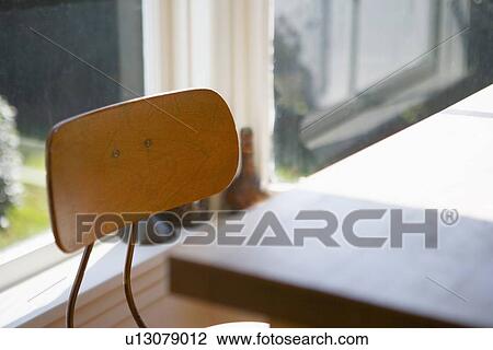 Stock Image - Top of old fashioned desk chair near table. Fotosearch