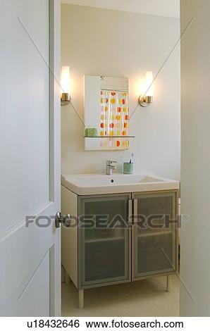 Stock Photograph - View of bathroom sink through open door. Fotosearch