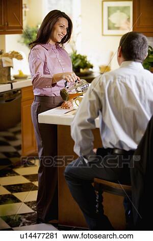 Stock Image - Woman pouring man beverage. Fotosearch