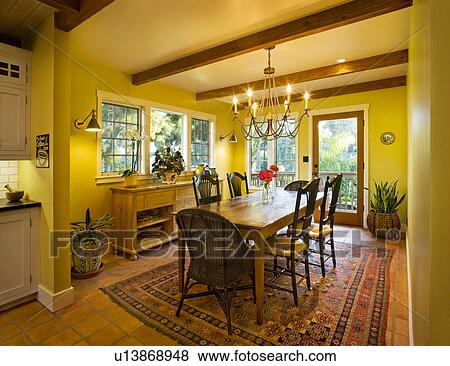 Yellow Dining Room With Wooden Ceiling Beams Stock Photo