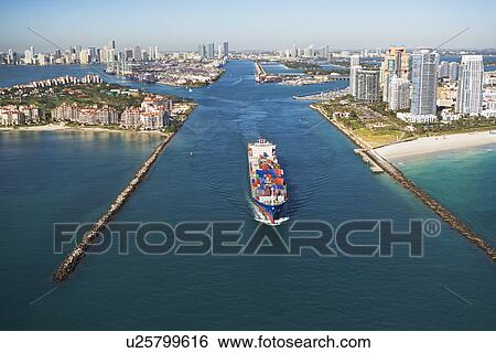 Stock Photograph - Aerial view of waterfront city and cargo ship. Fotosearch