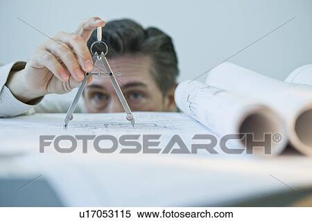 Stock Photography - Architect using drawing compass. Fotosearch