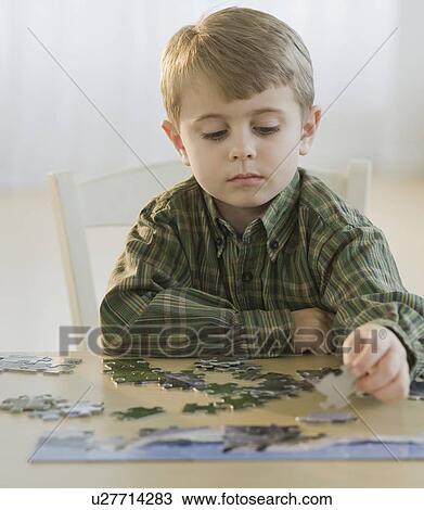 Stock Image - Boy assembling puzzle. Fotosearch