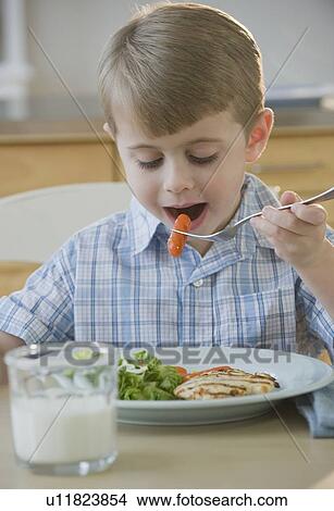 Boy eating dinner View Large Photo Image Picture - Boy eating dinner. Fotosearch
