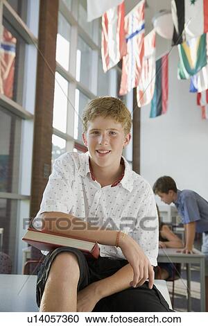 Boy holding book in library View Large Photo Image Stock Image - Boy holding book in library. Fotosearch