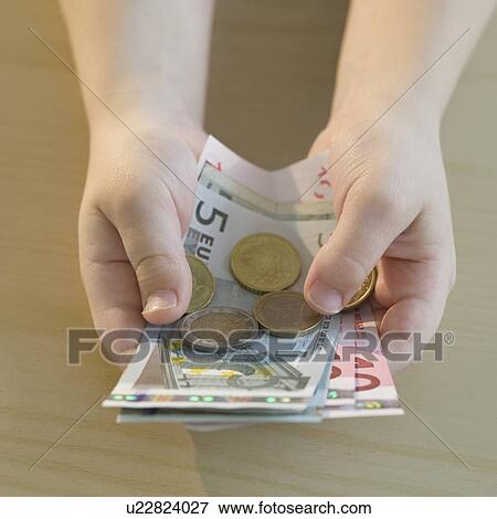 Stock Photo - Boy holding euros. Fotosearch