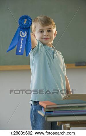 Stock Image - Boy holding first place ribbon. Fotosearch