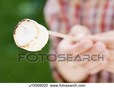 Boy holding roasted marshmallow View Large Photo Image Stock Image - Boy holding roasted marshmallow. Fotosearch