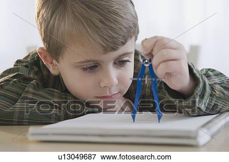 Stock Photo - Boy using drawing compass. Fotosearch