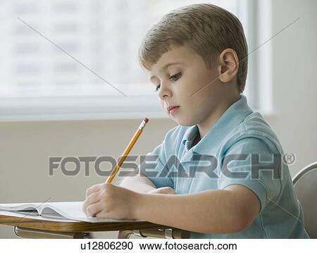 Boy writing in classroom View Large Photo Image Stock Image - Boy writing in classroom. Fotosearch