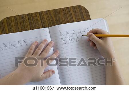 Boy writing letters in classroom View Large Photo Image Stock Photo - Boy writing letters in classroom. Fotosearch