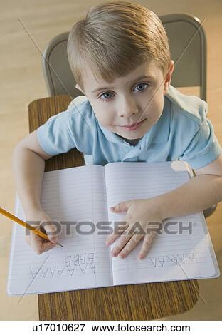 Boy writing letters in classroom View Large Photo Image Stock Photo - Boy writing letters in classroom. Fotosearch
