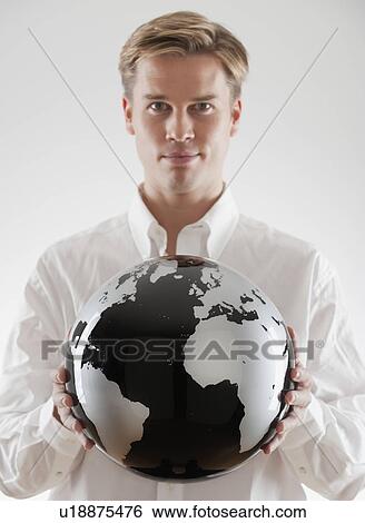 Stock Photograph - Businessman holding black and white globe. Fotosearch