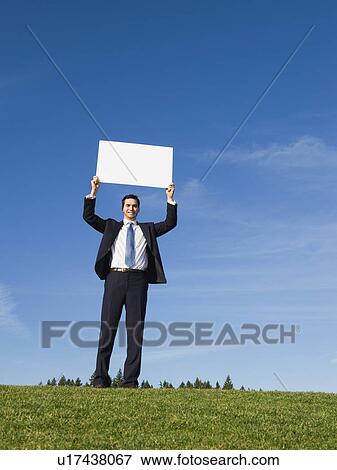 Stock Photo - Businessman holding blank sign. Fotosearch