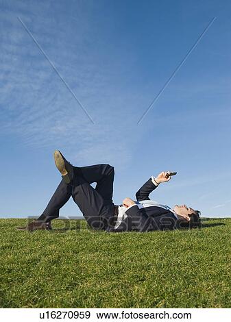 Businessman laying in grass View Large Photo Image Stock Photo - Businessman laying in grass. Fotosearch