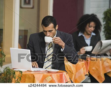 Businessman looking at laptop at outdoor cafe View Large Photo Image Picture - Businessman looking at laptop at outdoor cafe. Fotosearch