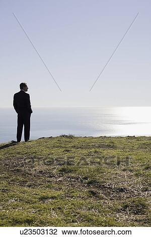 Businessman looking toward ocean View Large Photo Image Stock Image - Businessman looking toward ocean. Fotosearch
