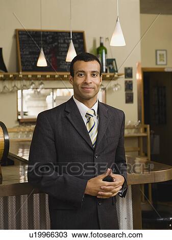 Stock Image - Businessman posing in restaurant. Fotosearch