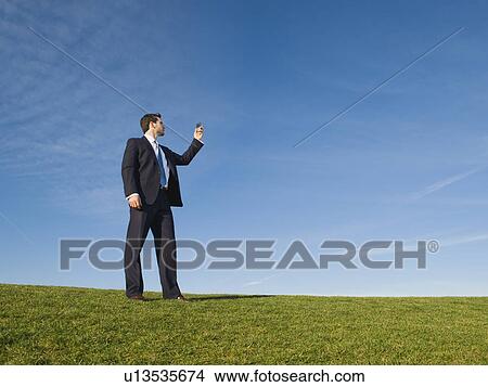 Picture - Businessman using cell phone outdoors. Fotosearch
