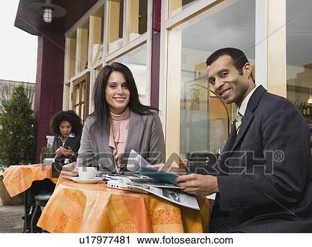 Stock Image - Businesspeople meeting at outdoor cafe. Fotosearch