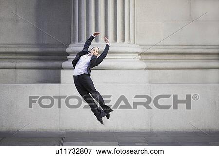 Businesswoman dancing in urban setting View Large Photo Image Stock Photo - Businesswoman dancing in urban setting. Fotosearch