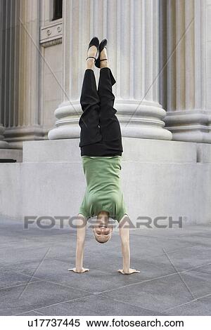 Businesswoman doing handstand on urban sidewalk View Large Photo Image Stock Photography - Businesswoman doing handstand on urban sidewalk. Fotosearch