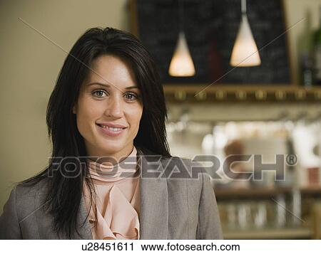 Stock Image - Businesswoman posing in restaurant. Fotosearch