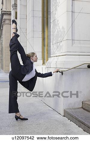 Businesswoman stretching on urban sidewalk View Large Photo Image Stock Image - Businesswoman stretching on urban sidewalk. Fotosearch