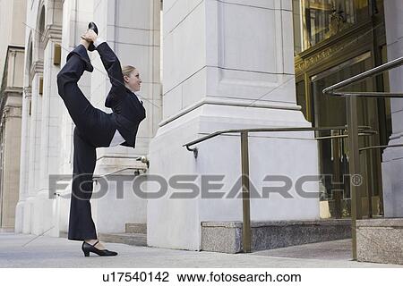 Businesswoman stretching on urban sidewalk View Large Photo Image Stock Image - Businesswoman stretching on urban sidewalk. Fotosearch