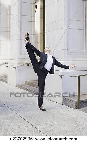 Businesswoman stretching on urban sidewalk View Large Photo Image Stock Photograph - Businesswoman stretching on urban sidewalk. Fotosearch