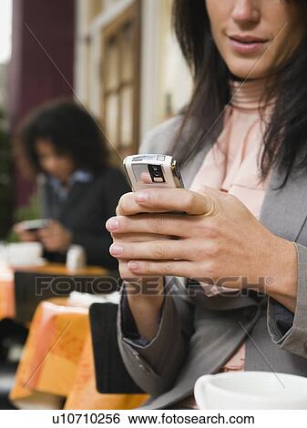Businesswoman text messaging at outdoor cafe View Large Photo Image Stock Photograph - Businesswoman text messaging at outdoor cafe. Fotosearch