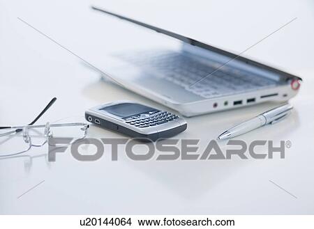 Cell phone and laptop on desk View Large Photo Image Picture - Cell phone and laptop on desk. Fotosearch
